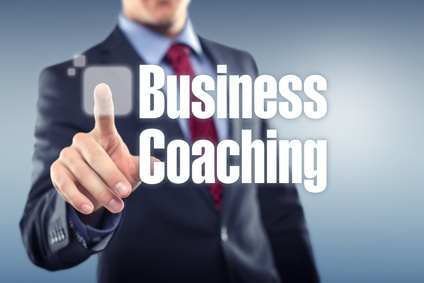 Mann der auf ein Schild tippt mit der Aufschrift: Business Coaching
